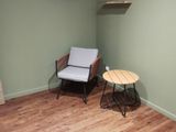 une pièce avec un canapé, un fauteuil et des étagères fixées au mur