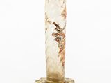 a glass vase with a bird on it on a stand
