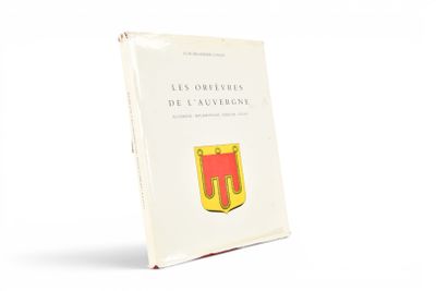 un vieux livre posé sur une table blanche à côté d'un mur blanc