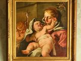 un tableau représentant une femme tenant un bébé dans ses bras, accroché au mur