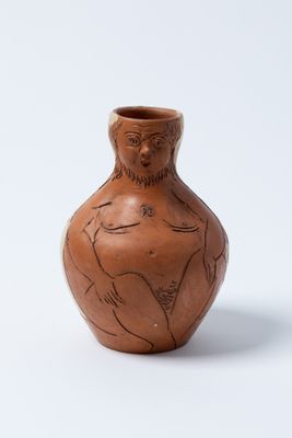 un petit vase marron sur lequel est représentée une femme