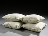 three white pillows stacked on top of each other on a table