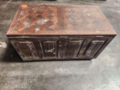 a wooden chest sitting on the floor in a warehouse