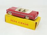 an old red toy car sitting on top of a yellow box