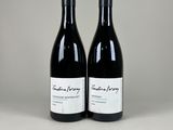 deux bouteilles de vin rouge posées l'une à côté de l'autre sur une table