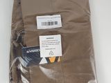 un pantalon marron dans un sac en plastique posé sur une surface blanche