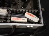 a metal case with tools in it on a black surface