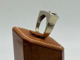 sterling silver ring on a wooden box with a white background