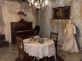une salle à manger avec une table, des chaises et un piano