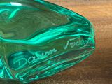 a green glass bottle that is sitting on a table
