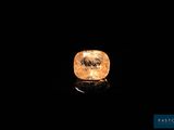 a yellow diamond on a black surface in the dark