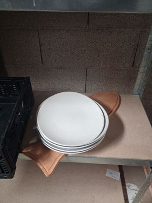 une pile d'assiettes sur une étagère à côté d'un micro-ondes