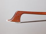 a close up of a knife with a wooden handle on a gray background