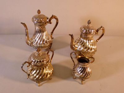 two silver teapots sitting next to each other on a table