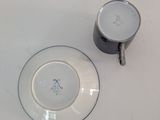 a cup and saucer sitting on a white table