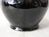 a black vase that is sitting on a table