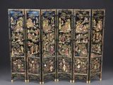 three black and gold decorated screens with figures on them