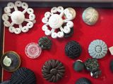 many different types of buttons on display in a display case