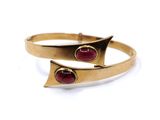 a close up of a gold ring with two red stones on it