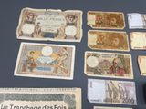 some old french bank notes sitting on top of a table