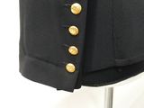 a close up of a black jacket with gold buttons on a mannequin