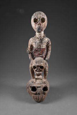 une statue en bois représentant un squelette et un personnage humain