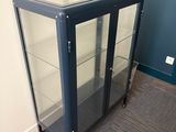 une vitrine en verre avec un socle noir et des étagères en verre