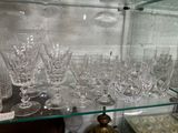 une étagère en verre sur laquelle sont posés de nombreux verres à vin