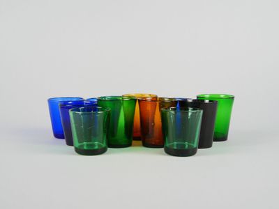 plusieurs verres à shot de différentes couleurs alignés sur une surface blanche