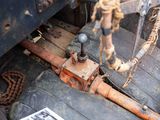 a rusted old car with a chain hanging from it ' s side