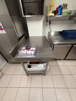a stainless steel table with magazines on it in a commercial kitchen