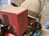 une bétonnière garée dans un garage, à côté d'un tas d'ordures