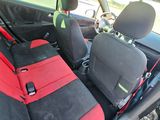 a red seat in the back of a car with two black seats