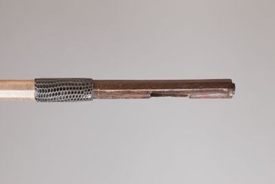 a close up of a wooden stick with a metal mesh on it