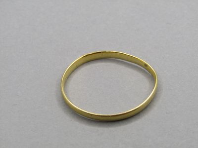 a close up of a gold ring on a white surface