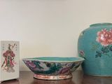a vase and a bowl sitting on a table next to a box