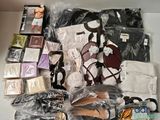 de nombreux sacs contenant des vêtements et des accessoires, disposés sur une table