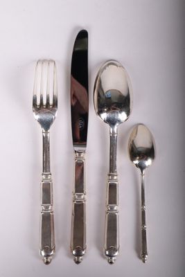 un plateau en argent sur lequel sont posés un couteau, une fourchette et une cuillère