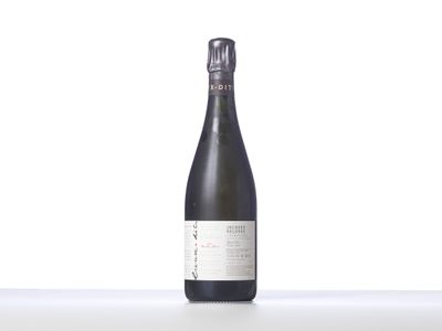 une bouteille de vin posée sur une table blanche