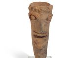 sculpture of a face on a stand on a white surface