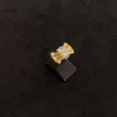 gros plan d'une bague en or et diamants sur une surface noire