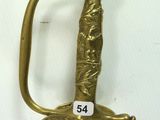 a gold sword with a handle on a white surface