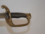 a close up of a sword on a white surface