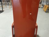 a red refrigerator sitting in a room with a red wall behind it