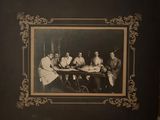 une vieille photo montrant un groupe d'hommes assis autour d'une table