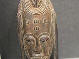 an image of a wooden mask on display in a glass case
