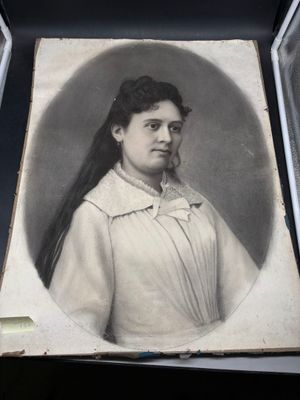 une vieille photo d'une femme aux cheveux longs vêtue d'une robe blanche