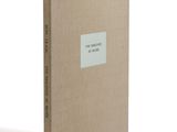 a brown book sitting on top of a table next to a white wall