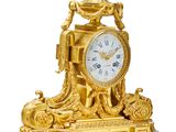 a gold clock that is sitting on a table