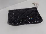 black purse on a white table with a white wall in the background